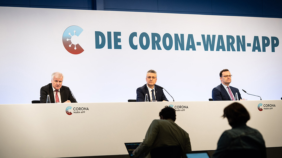 Bundesinnenminister Seehofer spricht in ein Mirkofon, neben ihm RKI-Präsident Wieler und Bundesgesundheitsminister Spahn vor Schriftzug und Logo der Corona-Warn-App 