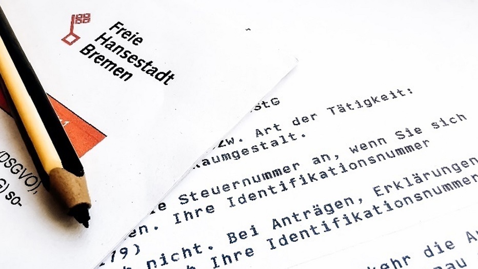 Text einer Pressemitteilung der Freien Hansestadt Bremen und ein Bleistift im Vordergrund
